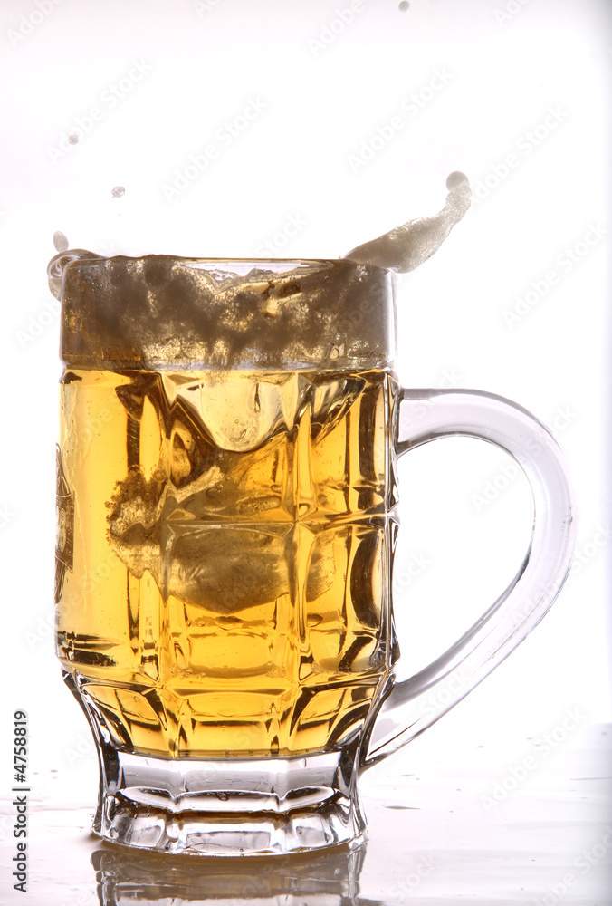 Ice splashing into a mug of beer