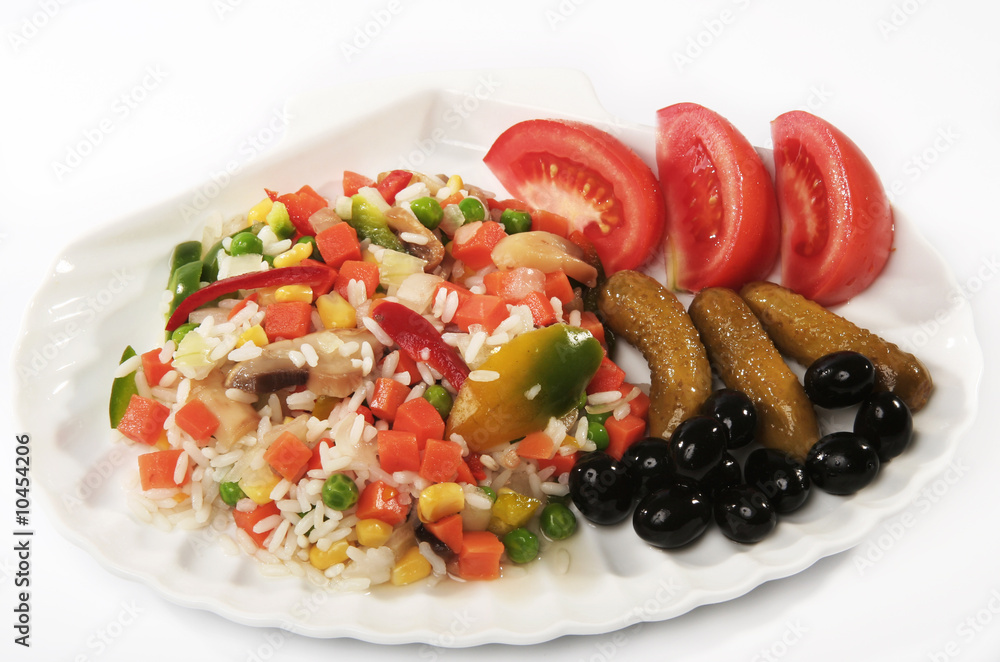 Risotto on a plate with tomatoes, olives and cucumbers