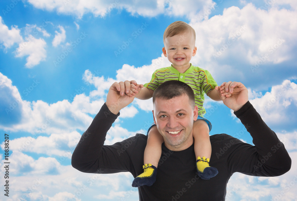 Little son sits on father shoulders