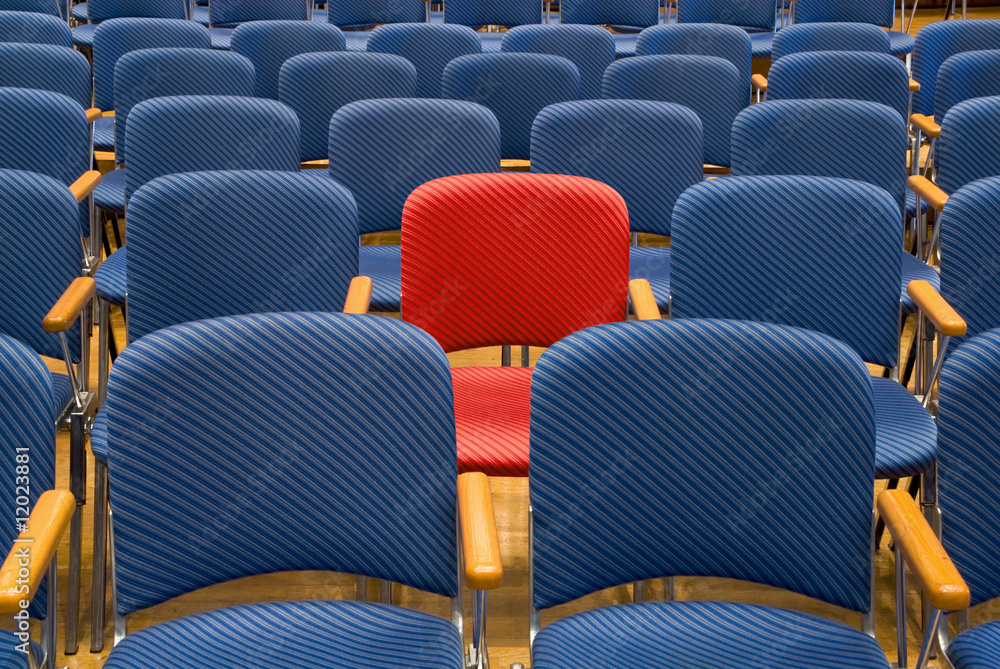 Roter Sitz unter vielen blauen