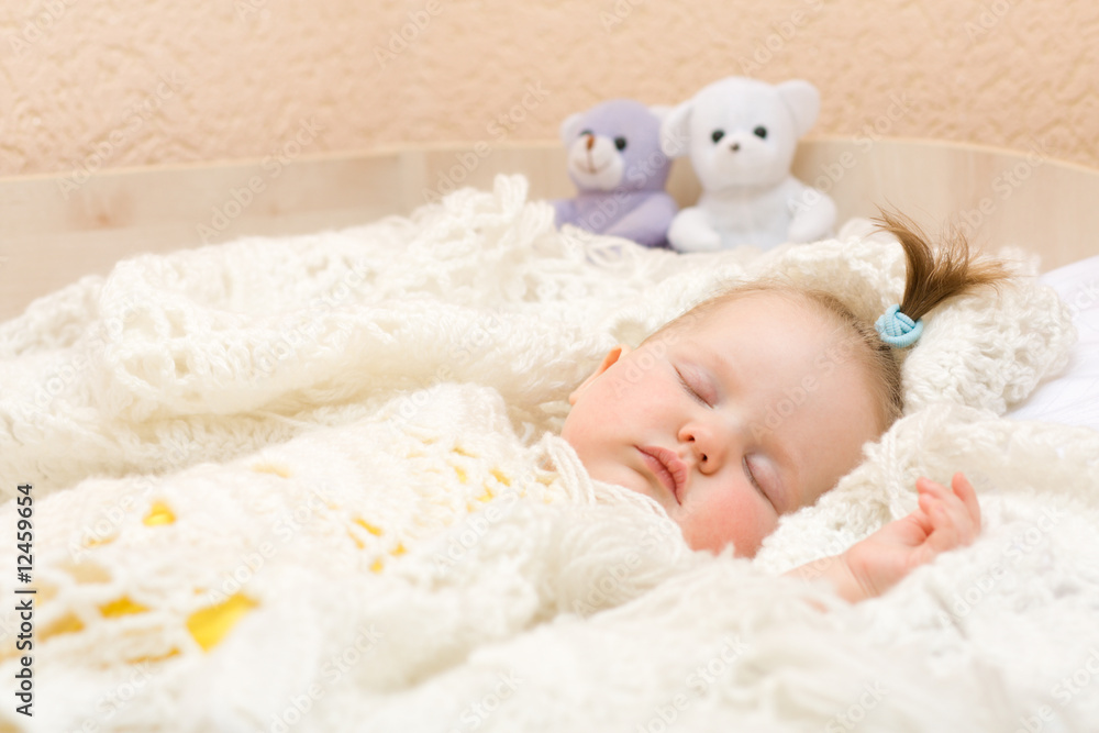 Baby sleeping with her bear toy