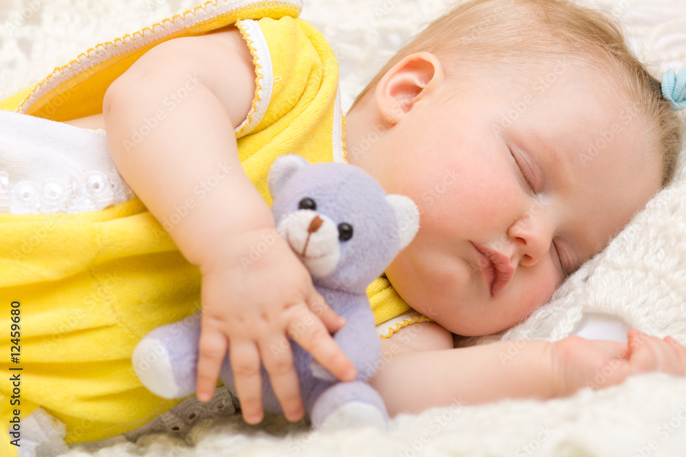 Baby sleeping with her bear toy