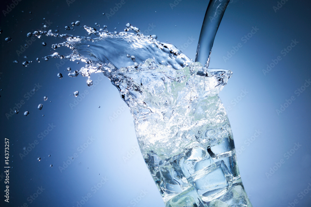 Glass of pouring water with ice