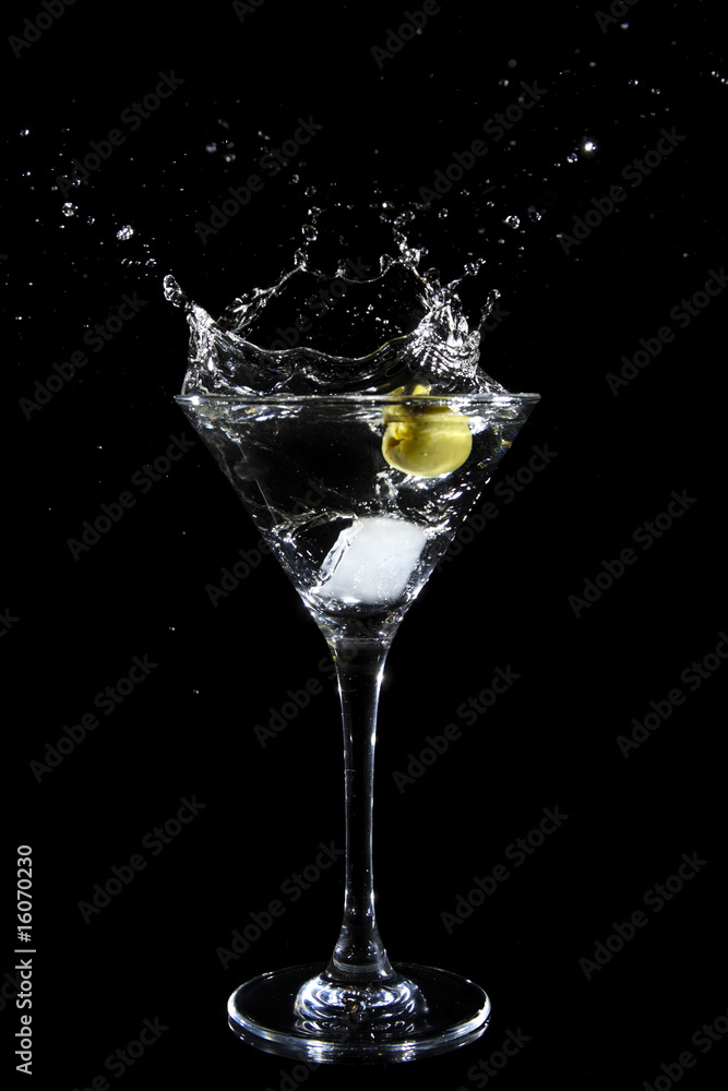 Splashing olive into a martini glass