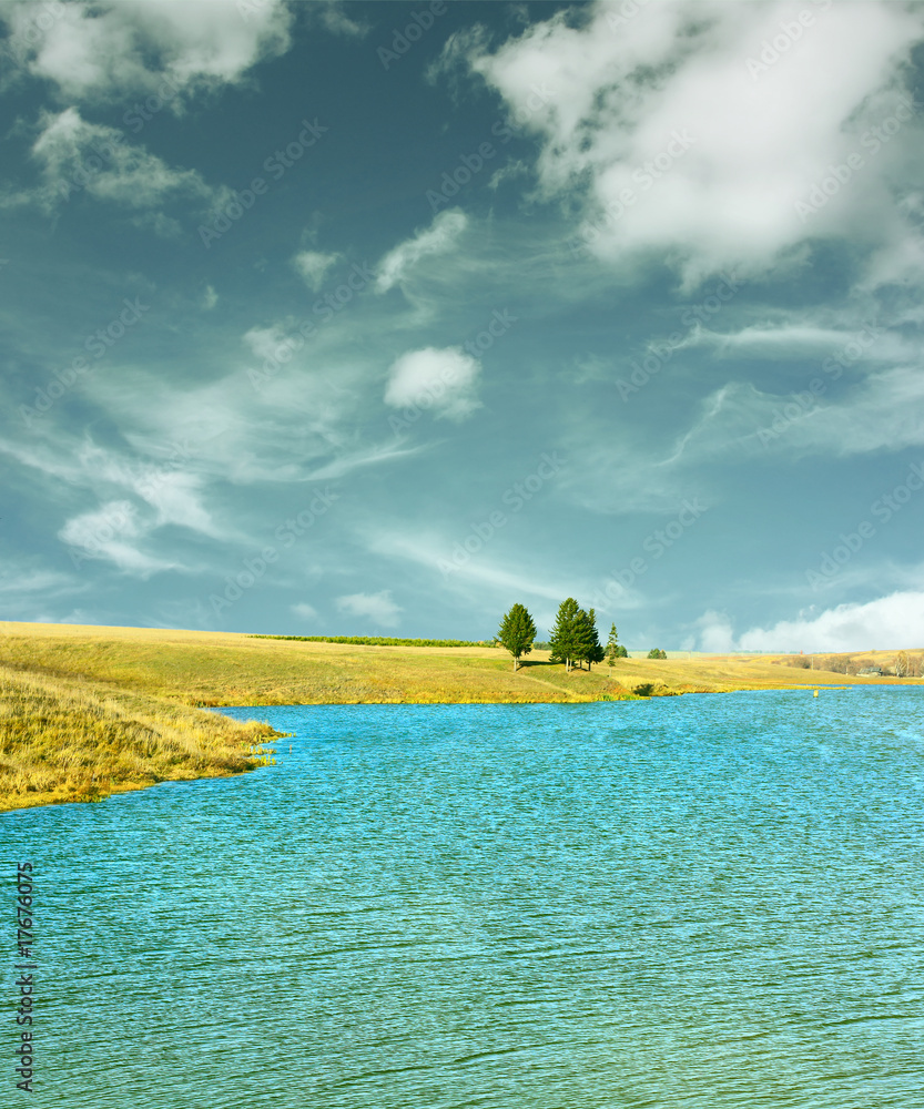 The coast of the lake with blue sky and clouds