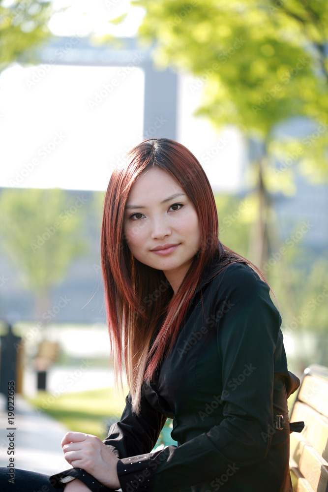 yong asian women sitting on chair outside