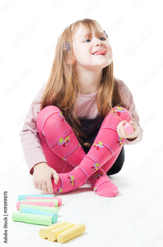 Little girl with chalks stick her tongue out