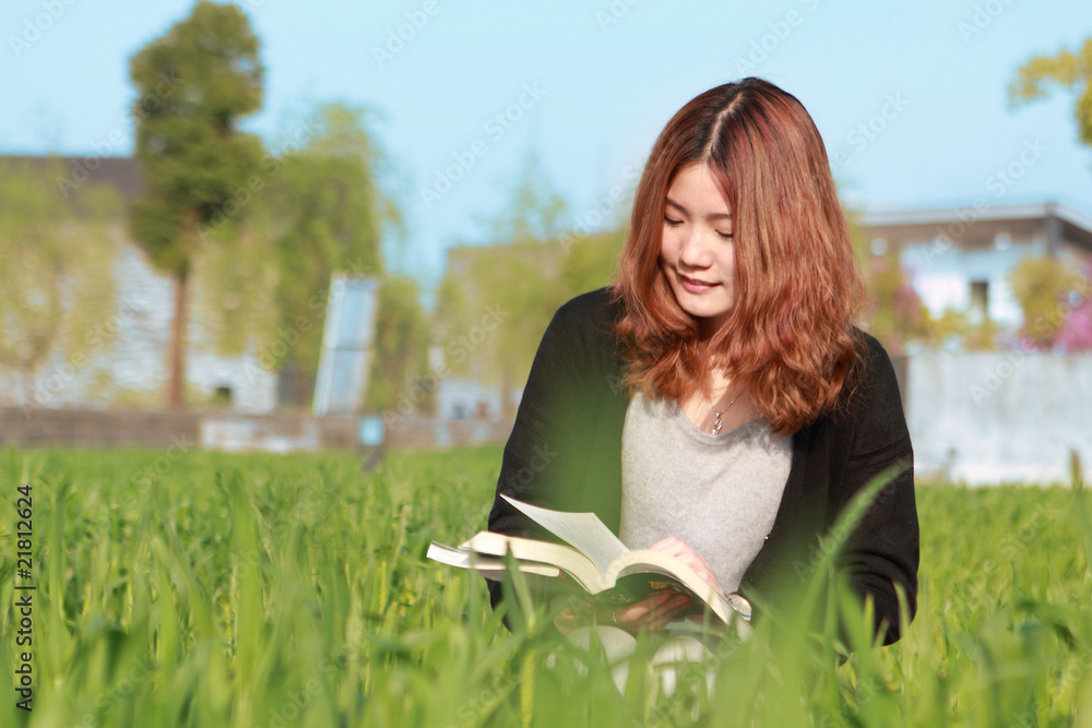 年轻的亚洲女孩户外阅读