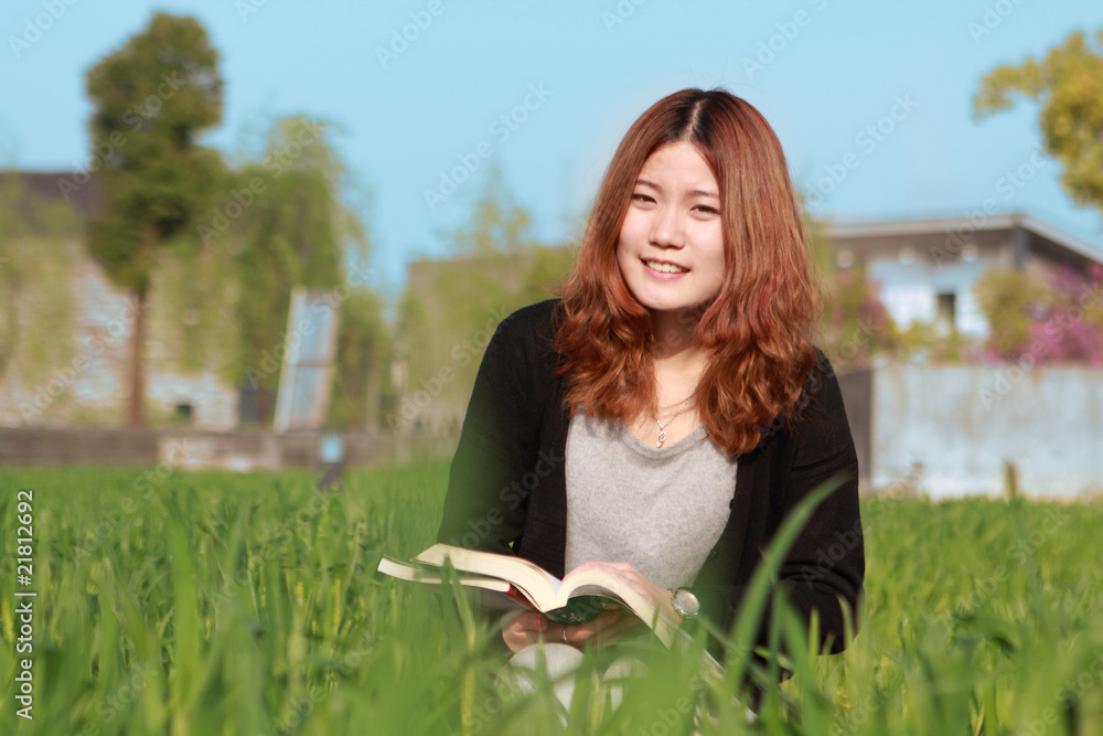 young asian girl reading outdoor