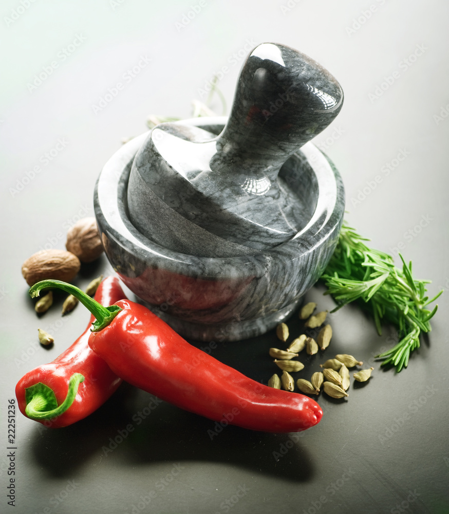 Mortar with pestle and Herbs.Over black background