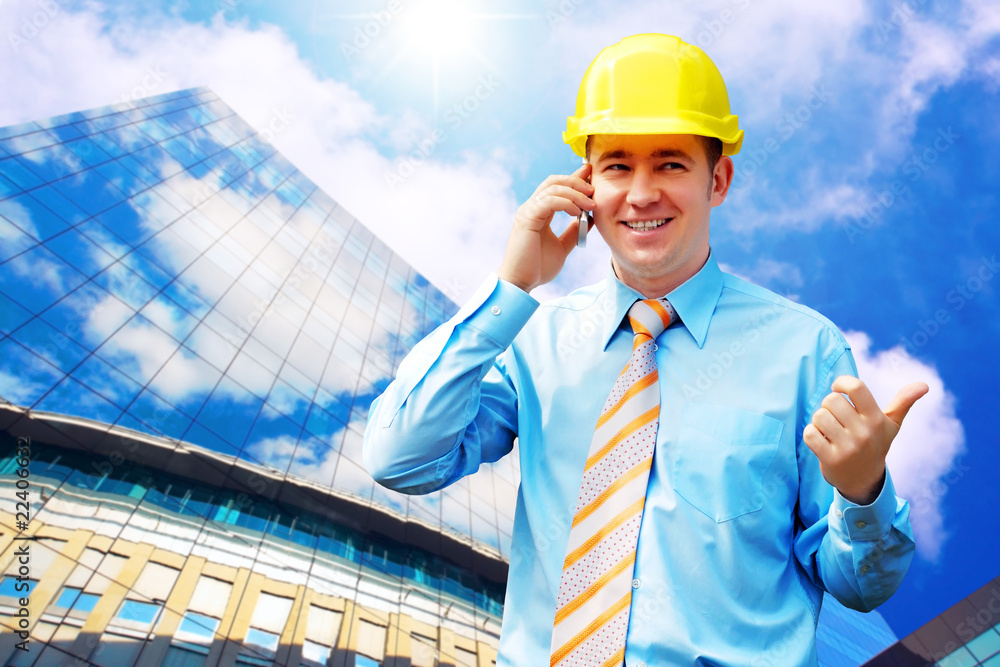 Young architect wearing a protective helmet standing on the buil