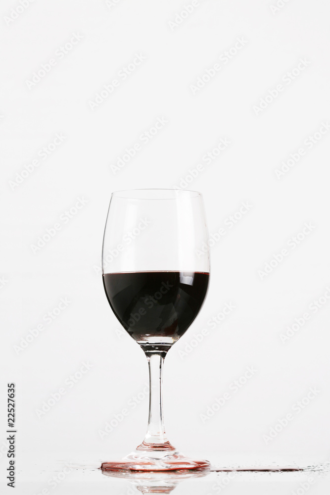 Red wine in wineglass isolated on white background ..