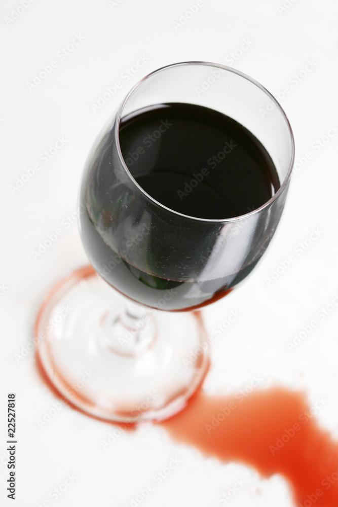 Red wine in wineglass isolated on white background ..