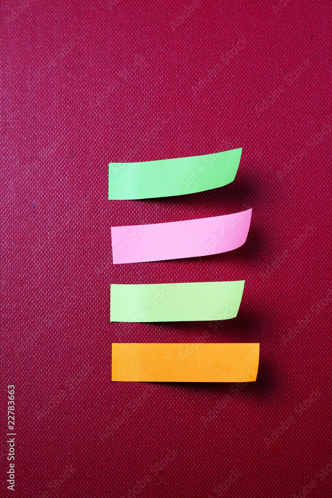 colored sticky notes isolated on red background .