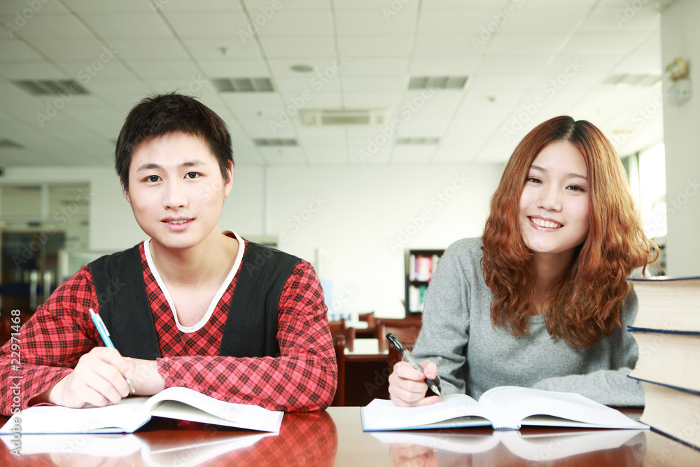 在图书馆学习的亚洲男孩和女孩