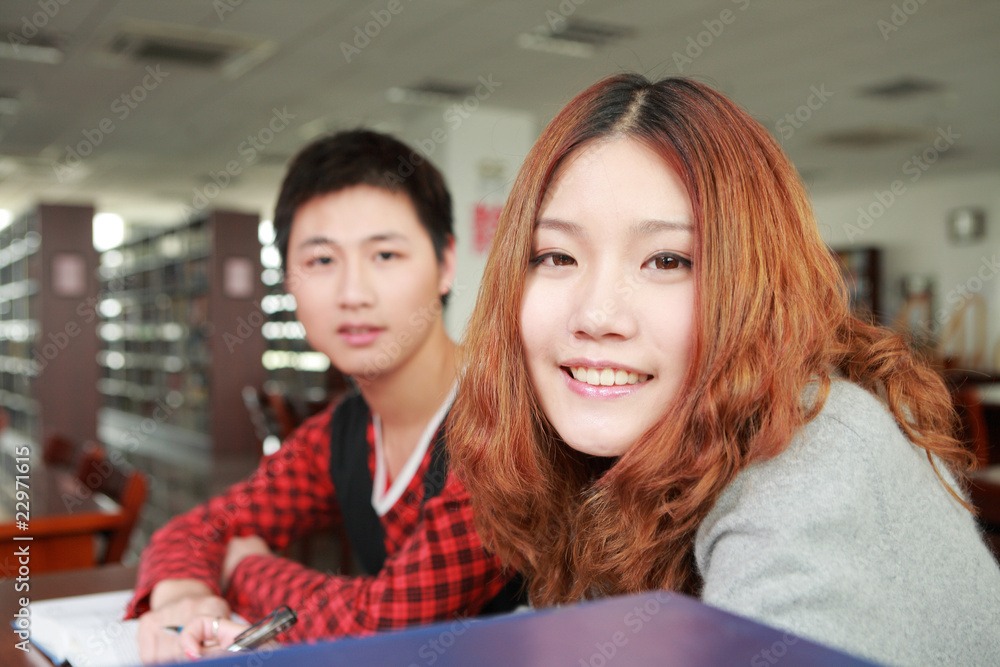 在图书馆学习的亚洲男孩和女孩