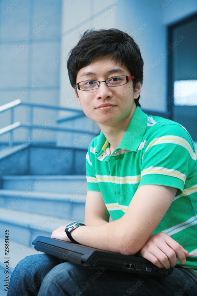 asian male student with laptop