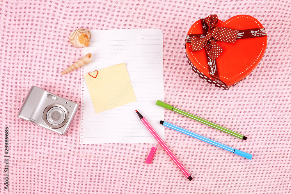 Clutter of objects stacked on pink background