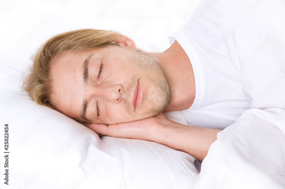 Young Man Sleeping on the white Bed