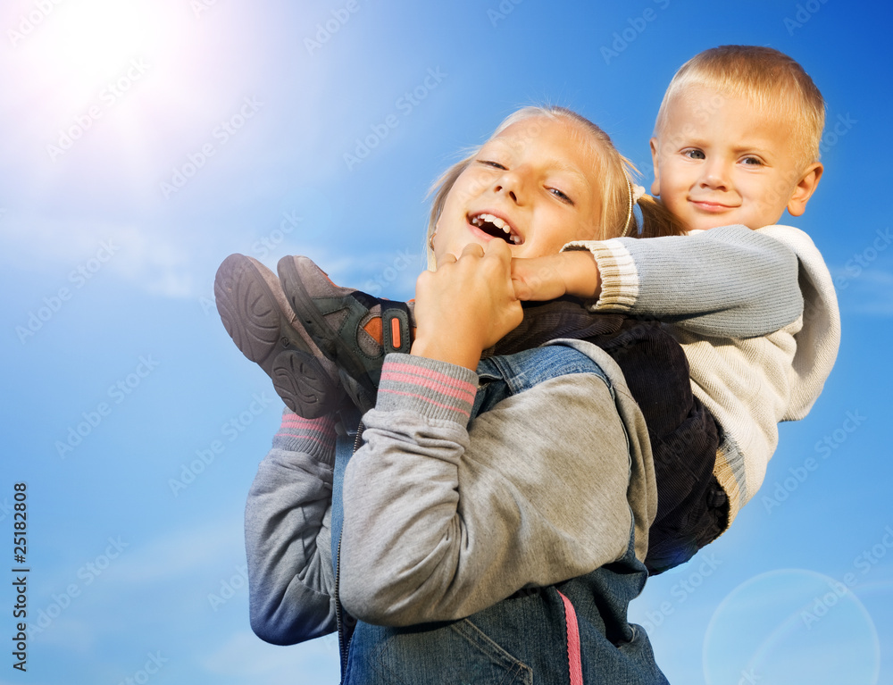 Happy Kids.Sister and Brother Over Blue Clear Sky