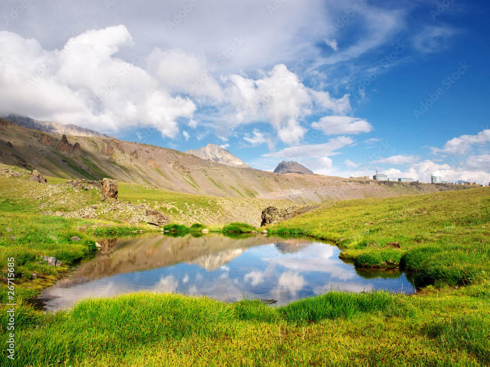 Lake amongst green meadow