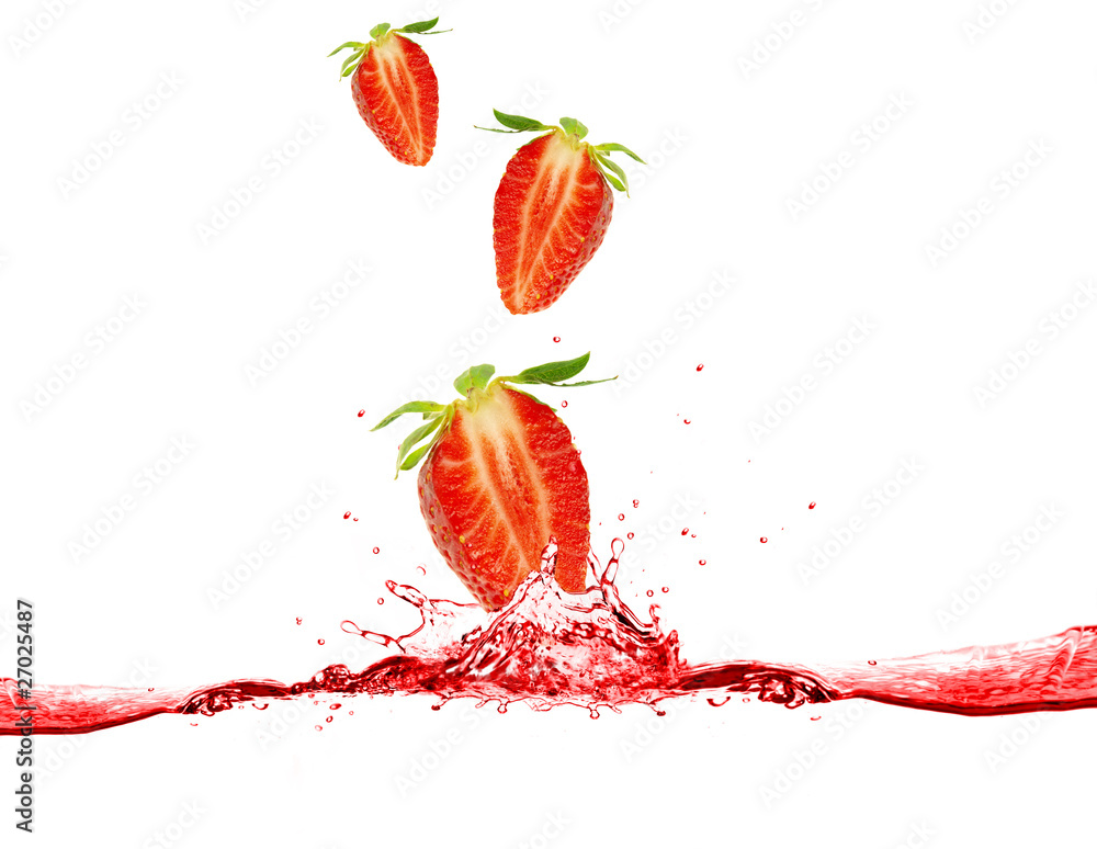 Strawberries dropped into water, isolated on white background