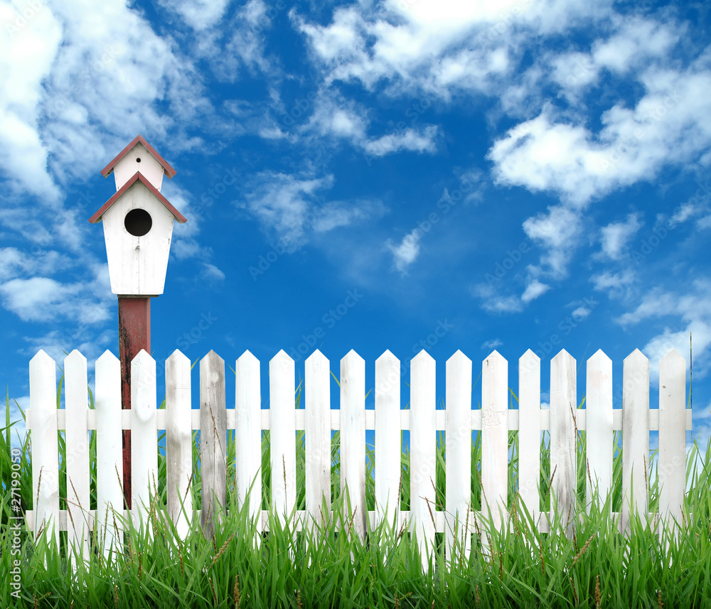 birdhouse white fence and blue sky