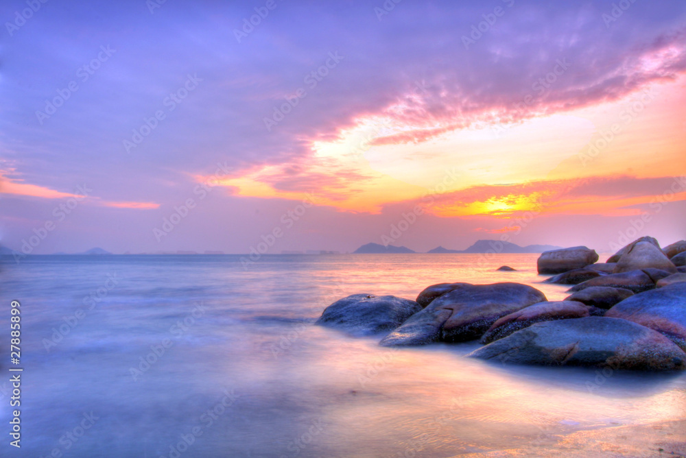 Sea and rock at the sunset under long exposure.