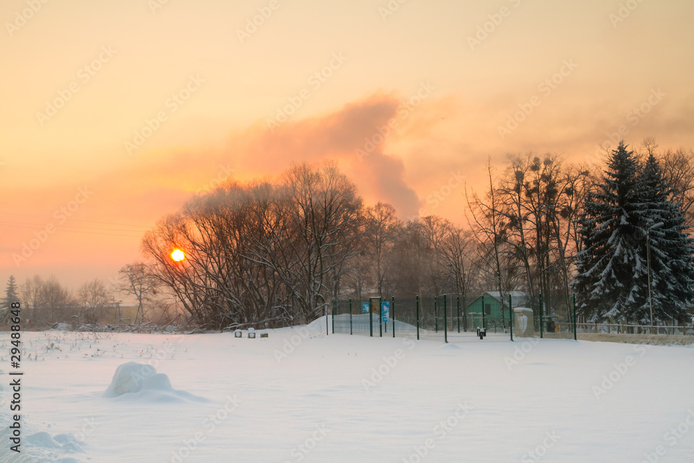 Winter sunrise over snowy polish meadow