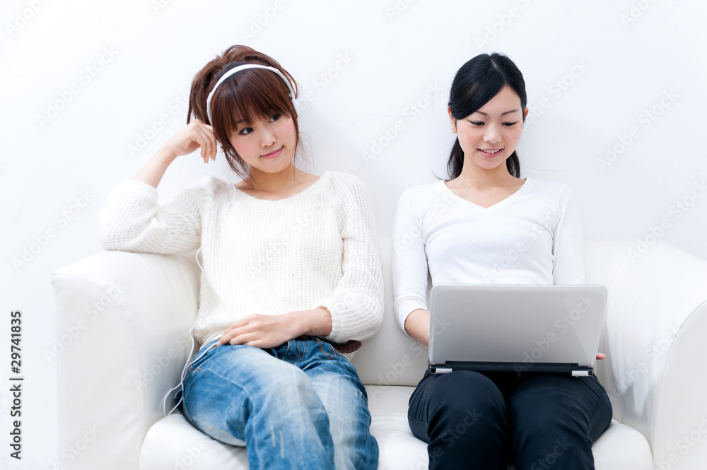 two beautiful asian women relaxing on the sofa