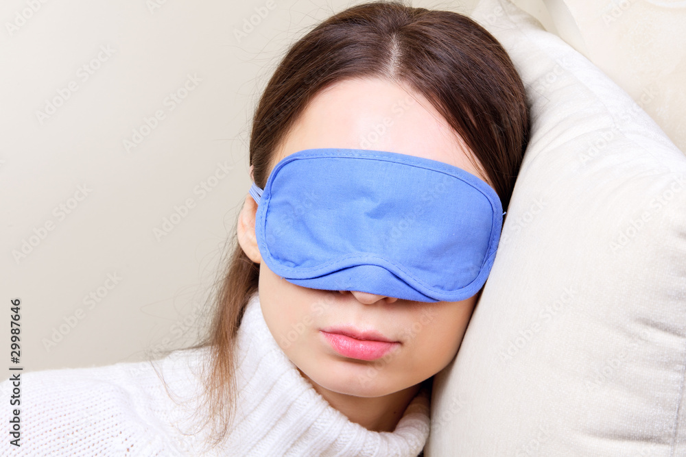 Young woman in a sleeping eye mask taking a nap