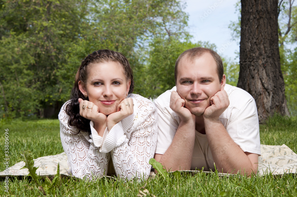 couple lays together on a grass