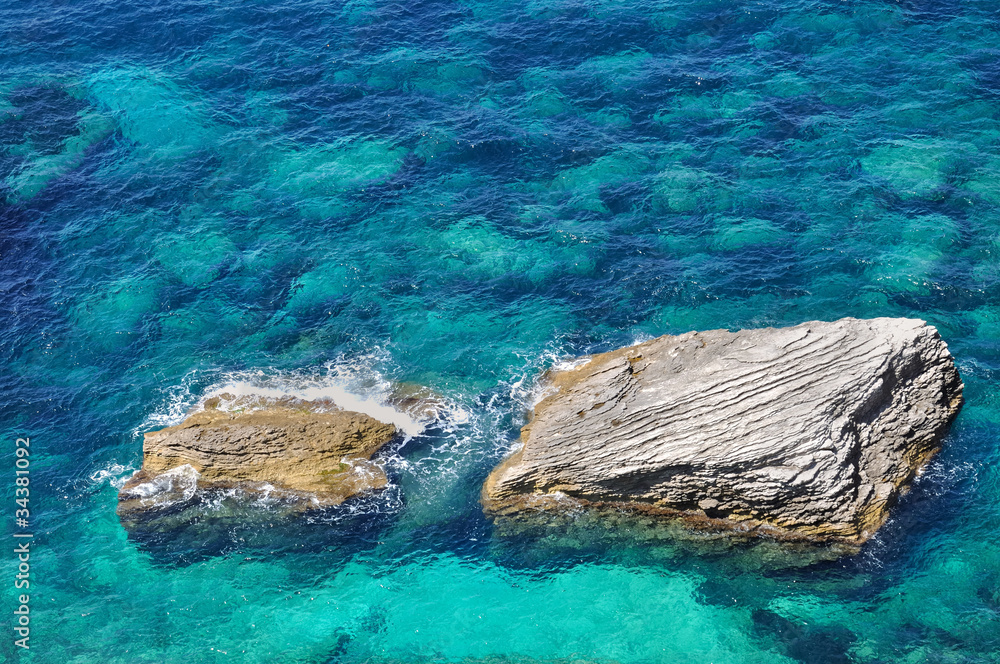 rochers dans eau bleu foncé et turquoise