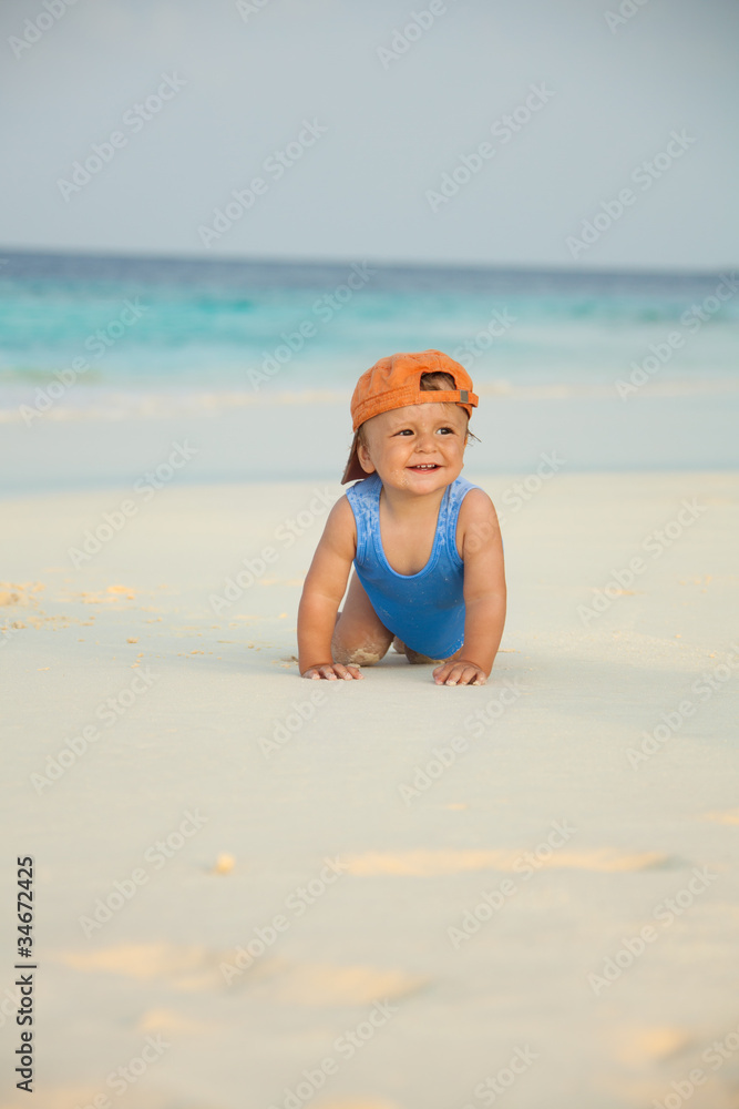 Happy kid crawling on the beach