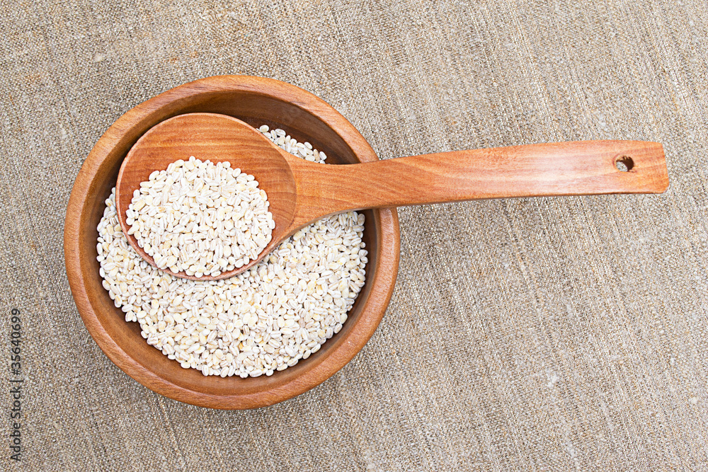 barley in wooden cup isolated on white