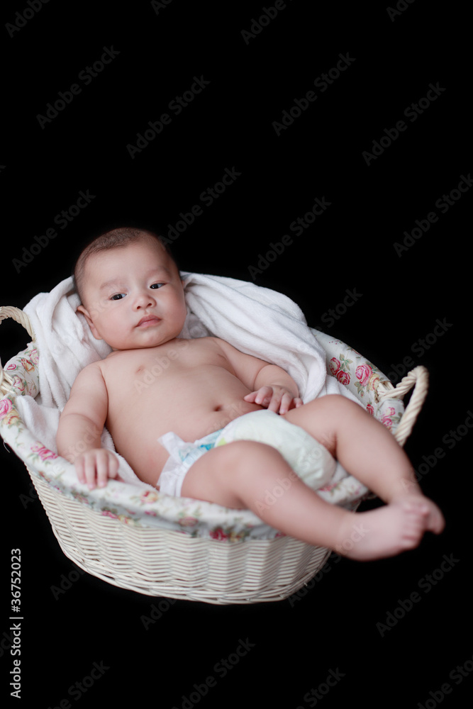 cute baby in  basket with black background