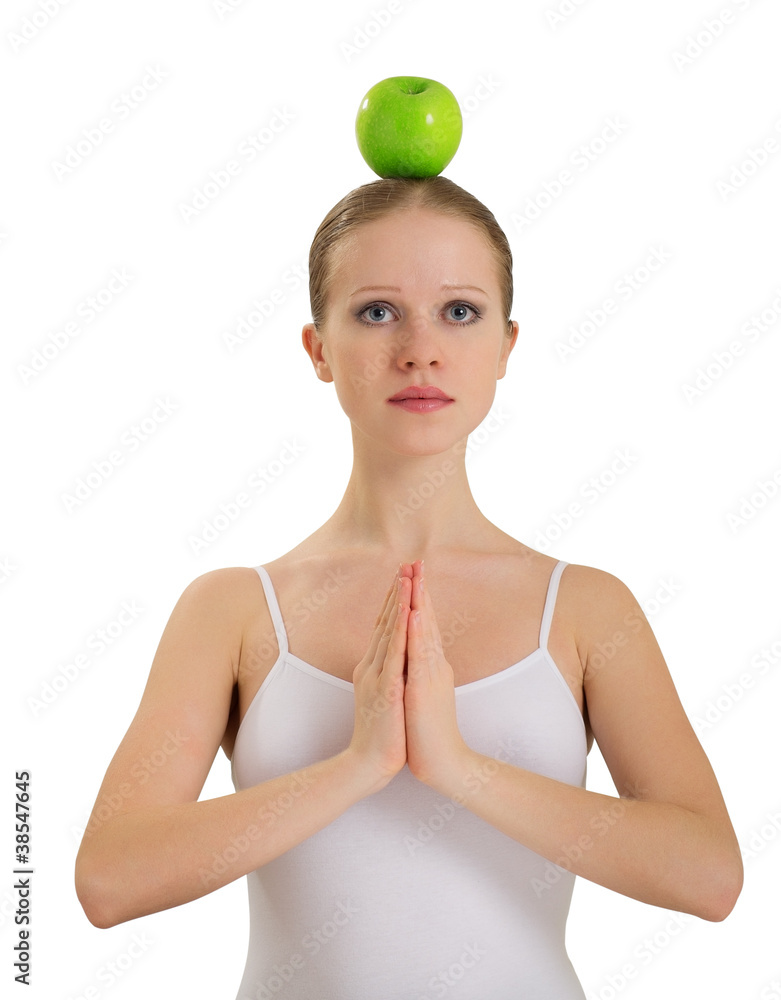 young woman meditating with apple on her head isolated