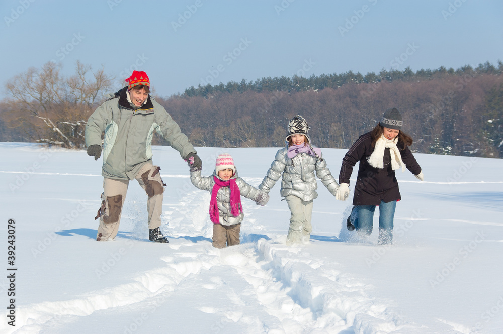 快乐的家庭冬季户外乐趣。父母带孩子，下雪