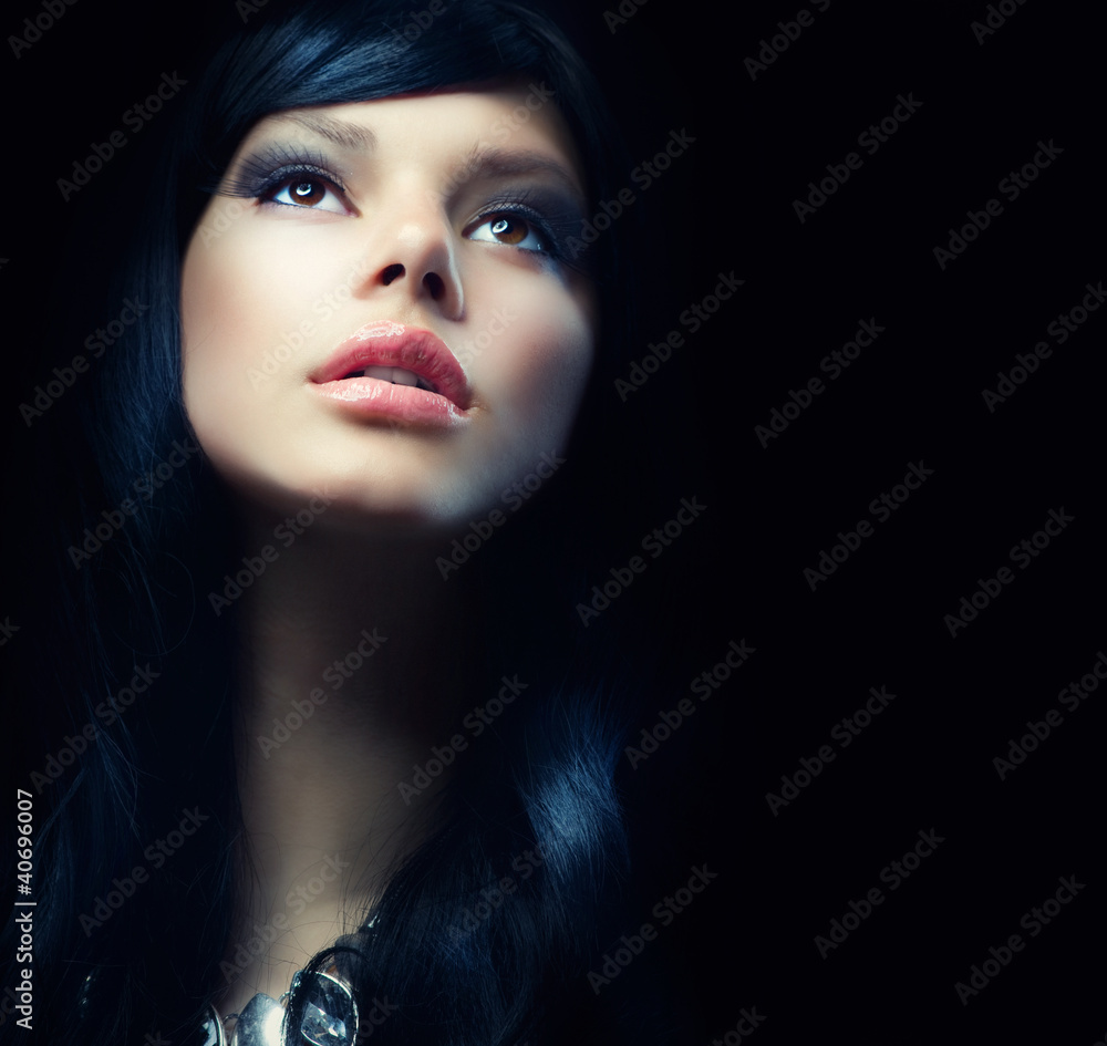 Beautiful Brunette Girl over Black Background. Darkness