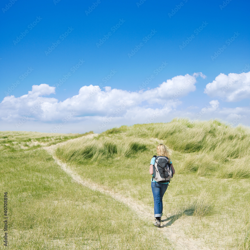 Frau wandert durch Dünen