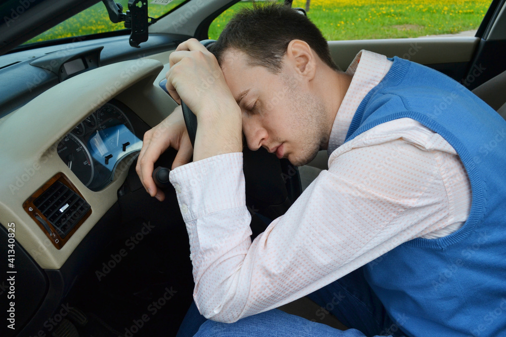 Man sleeps in a car.