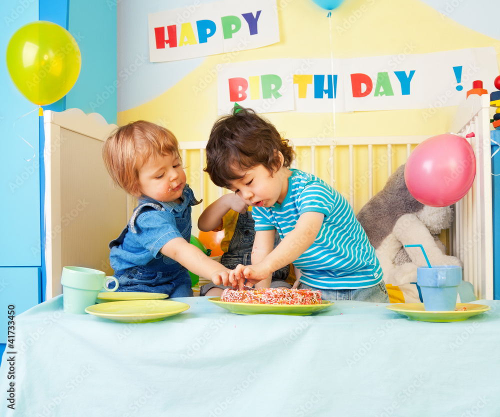 Two kids eating birthday cake