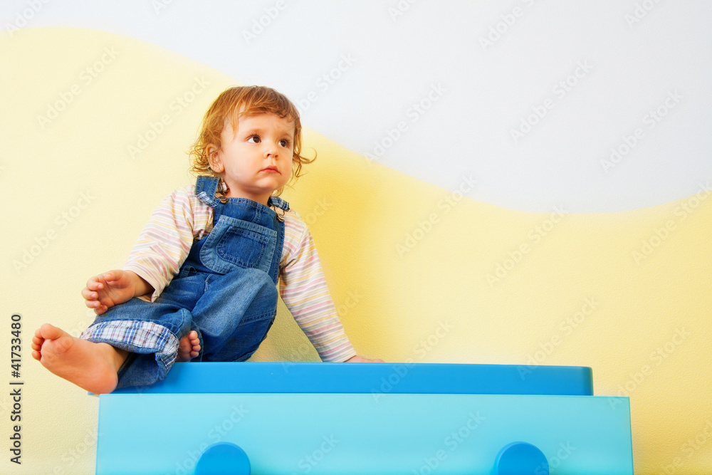 Happy kid sitting on the furniture