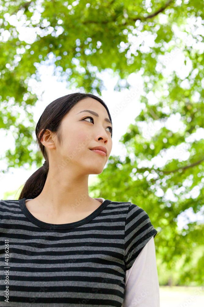 年轻的亚洲女人在森林里放松