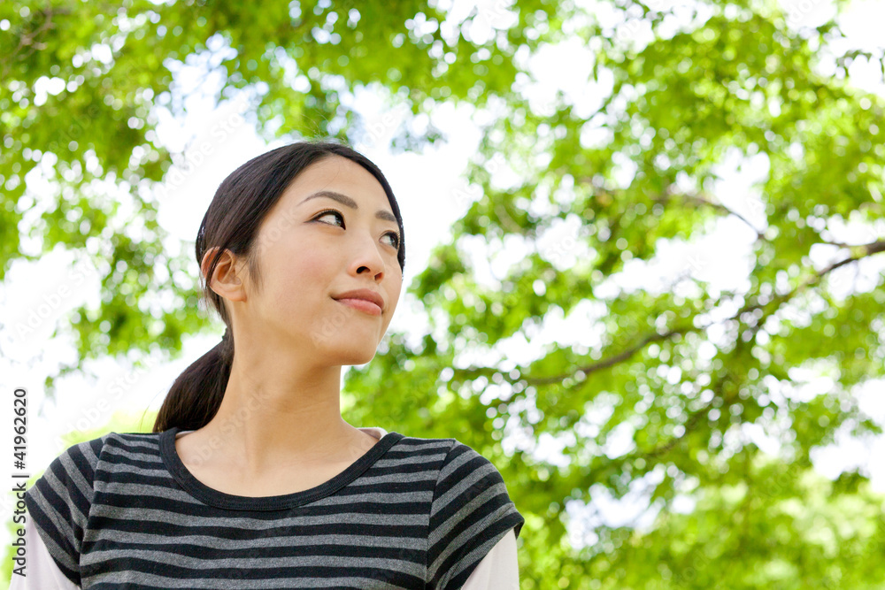 年轻的亚洲女人在森林里放松