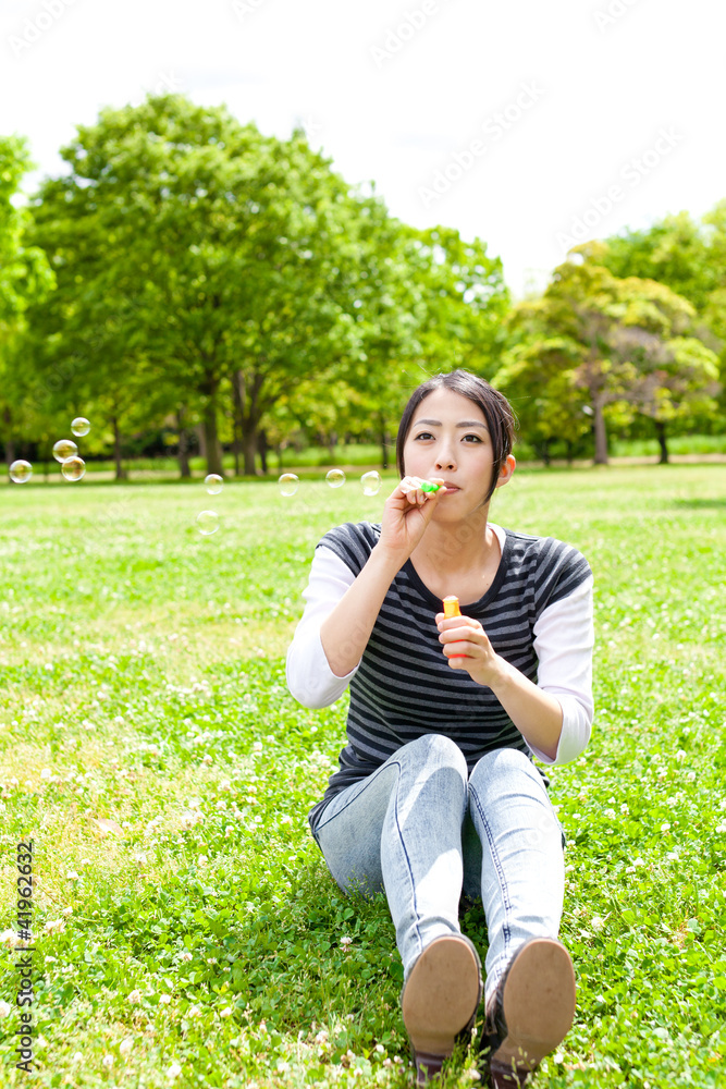 young asian woman with soap bubble in the park