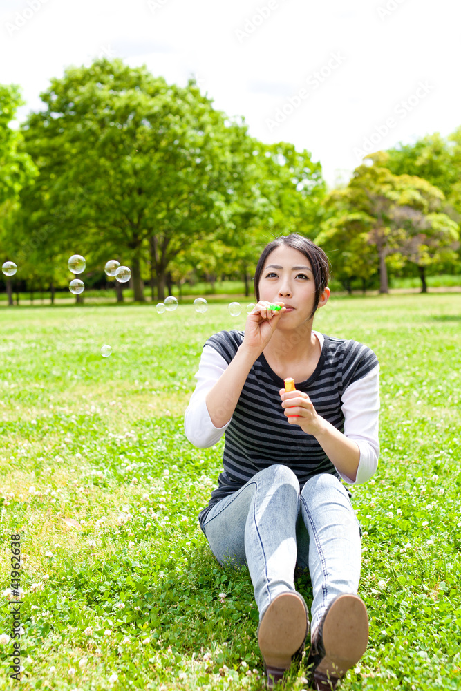 公园里带着肥皂泡的亚洲年轻女子