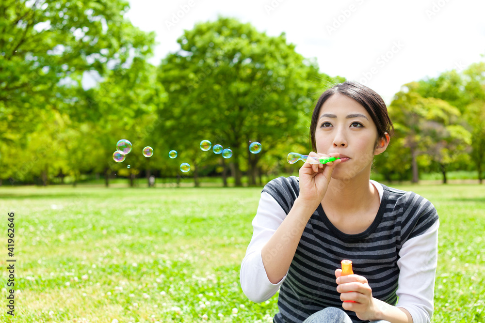 公园里带着肥皂泡的亚洲年轻女子