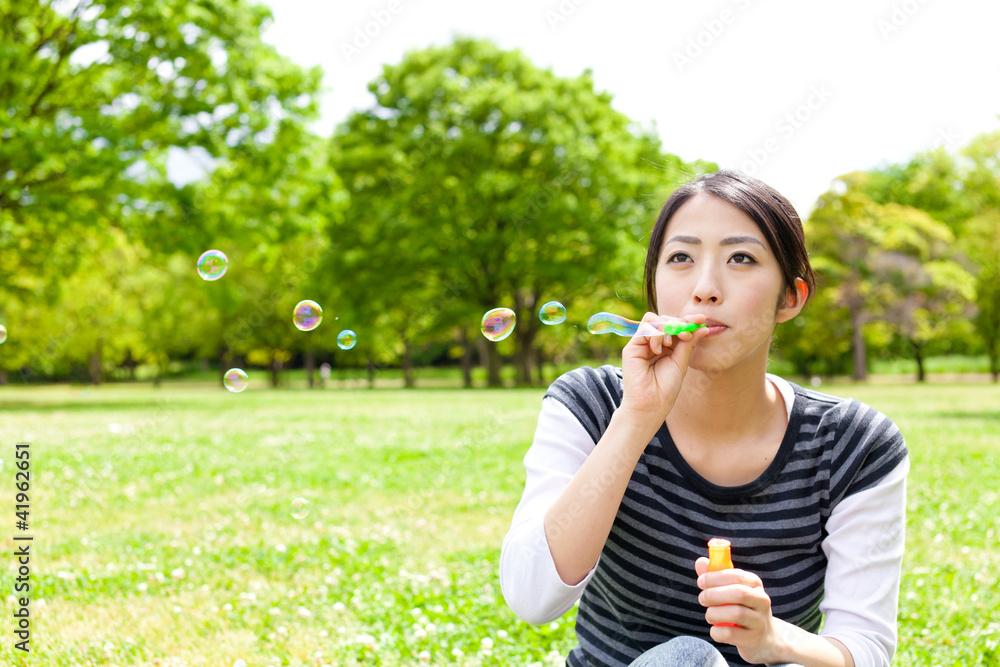 公园里带着肥皂泡的亚洲年轻女子