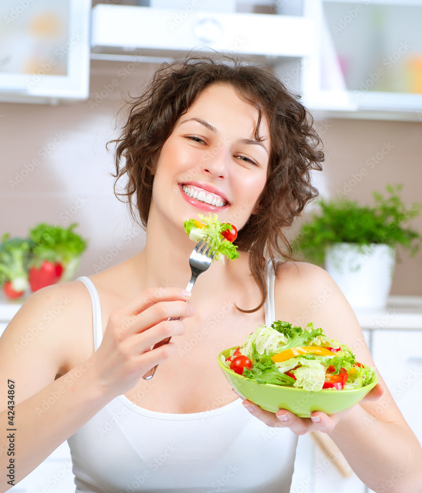 饮食。美丽的年轻女人吃蔬菜沙拉